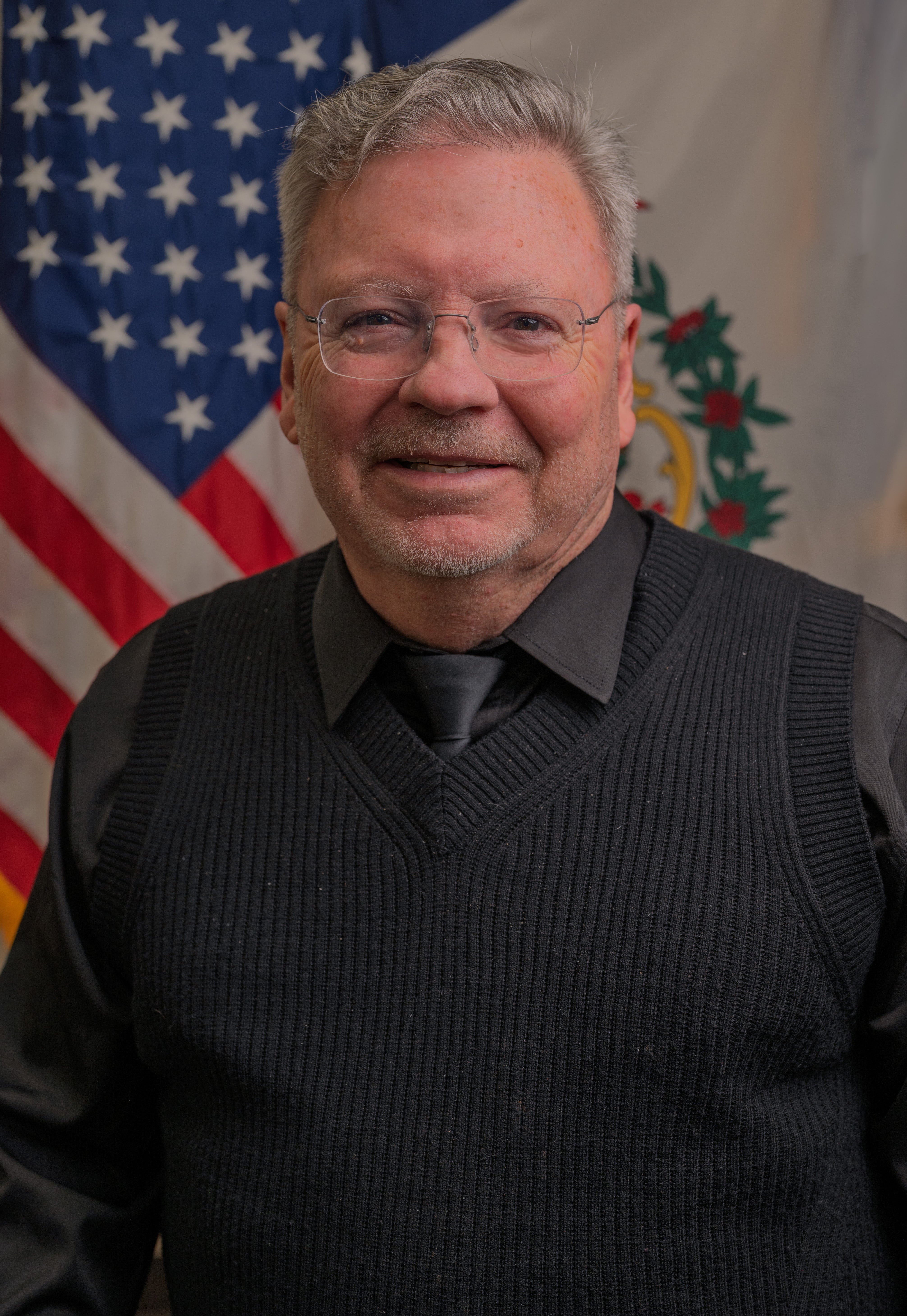Portrait of Randy Coleman in front of American Flag and WV State Flag