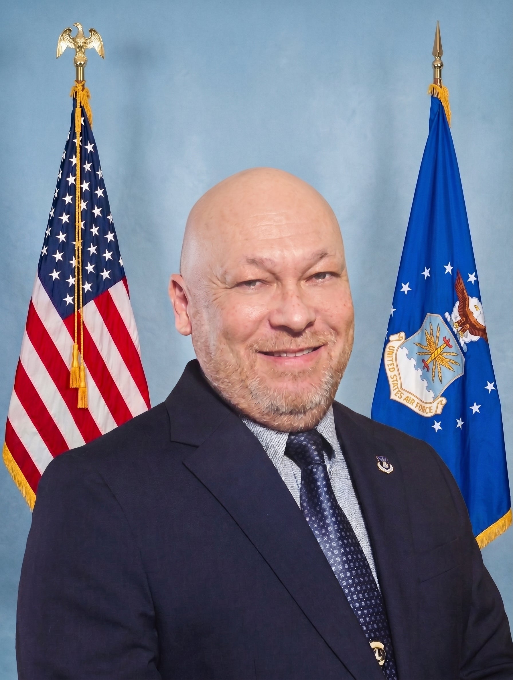 Portrait of Ron Deal standing between an American Flag and Air Force Flag